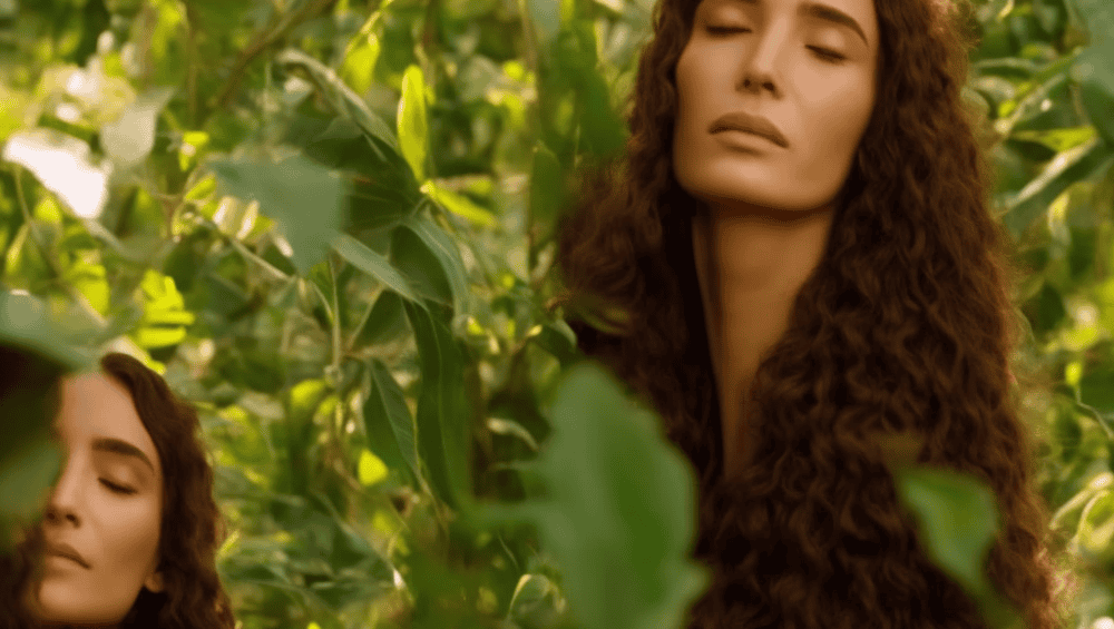 E, dark-haired woman gently massages Batana oil into her scalp, surrounded by lush greenery and a few scattered hair strands, with a subtle, warm golden glow illuminating her peaceful atmosphere